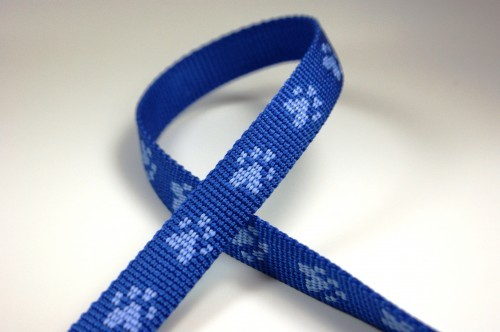 Bild von 20mm breites Pfötchengurtband, hellblau auf blau - 1m Rolle *ABVERKAUF*