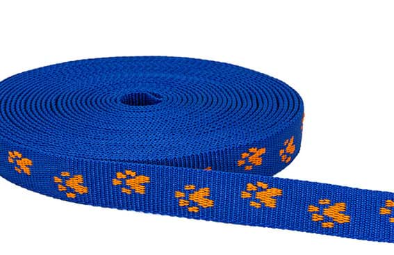 Bild von 25mm breites Pfötchengurtband, orange auf blau, 1m Rolle *ABVERKAUF*